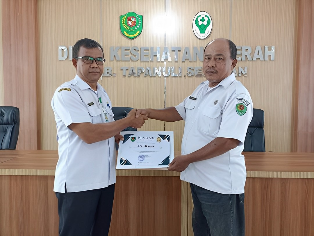 Foto: Ali Musa Lubis menerima piagam penghargaan dari Sekretaris Dinas Kesehatan Kabupaten Tapanuli Selatan atas dedikasinya dalam Pemberantasan Nyamuk Aedes Aegypti.