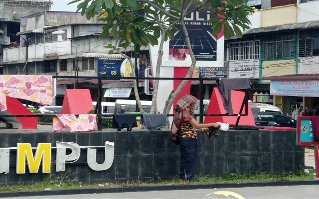 Keterangan Foto: Seorang perempuan menjemur pakaian di alun-alun Alaman Bolak Padangsidimpuan.