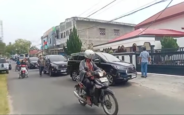 Keterangan Foto: Petugas KPK memasuki rumah Akhirun Piliang di tengah warga yang menyaksikan dari kejauhan.