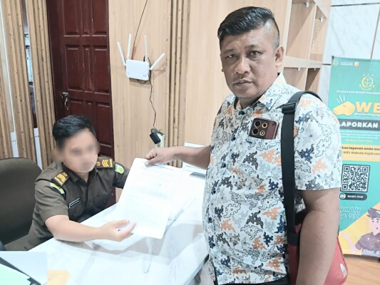 Stevenson Ompu Sunggu saat menyerahkan laporan pengaduan masyarakat ke Kejaksaan (KompasReal.com)